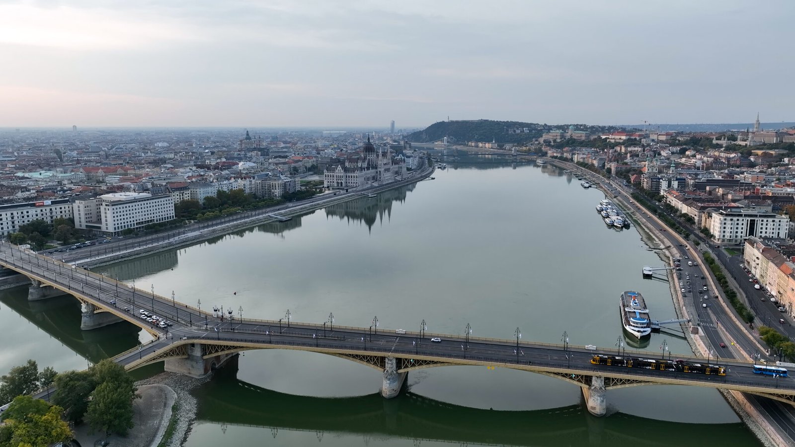 Establishing Aerial View Shot of Budapest, Hungary at sunrise. Margaret Bridge or Margit hid over River Danube, embankment