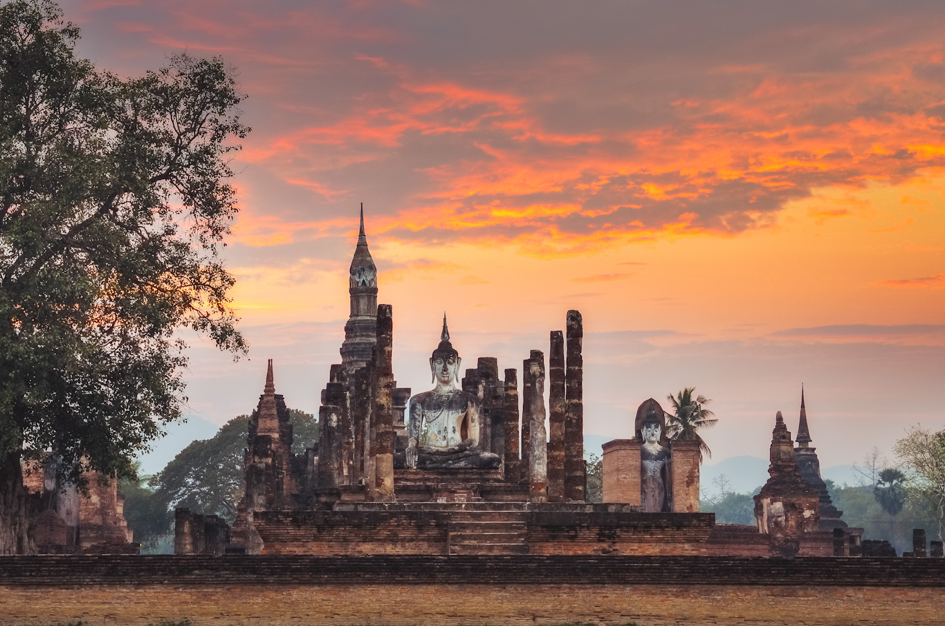 Sitting Budha at sunset in Wat Mahathat, Sukhothai historical park, Thailand